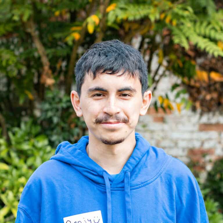 Educamps day camp leader wearing a blue Educamps hoodie, smiling outdoors and supporting children’s summer activities in nature.