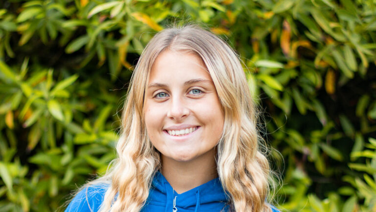 Educamps day camp leader wearing a blue Educamps hoodie, smiling outdoors and supporting children’s summer activities in nature.