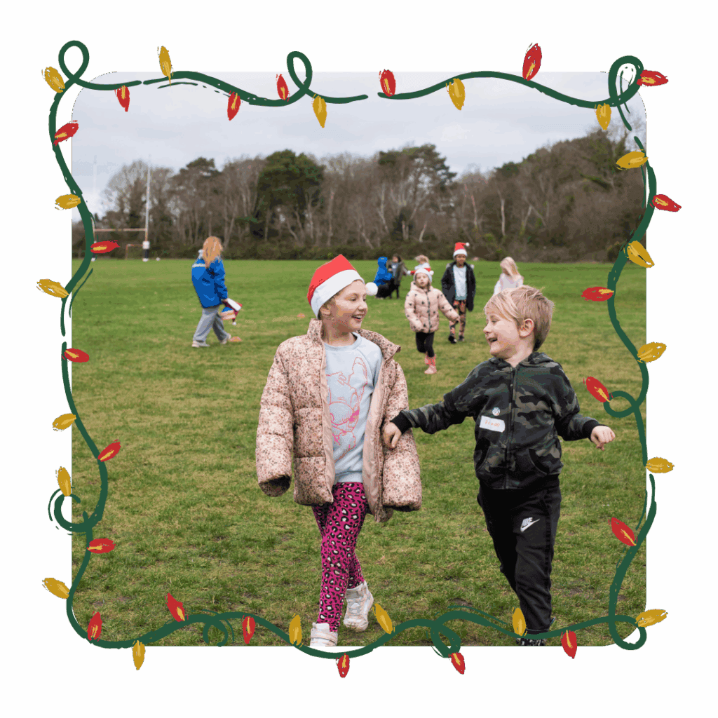 Children wearing festive hats and winter clothing laughing and walking together during an outdoor activity at an Educamps winter day camp.