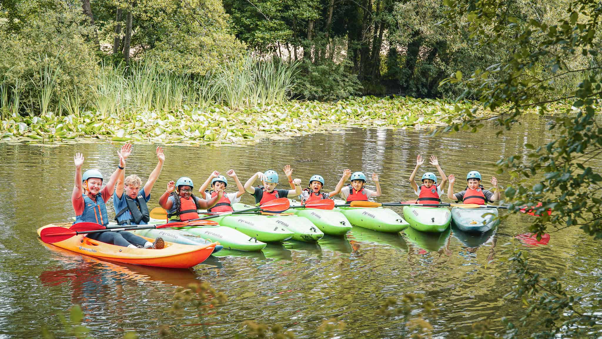 junior new forest camp, a group of kids kayaking on a lake.
